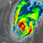 A mix of sun and clouds with a passing shower, high 90